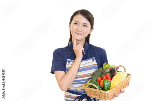 野菜を持つ笑顔の女性
