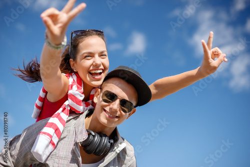 smiling teenagers in sunglasses having fun outside