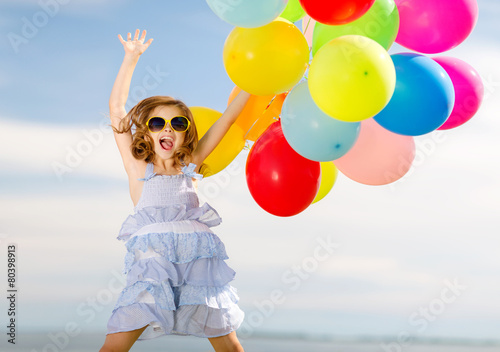 happy jumping girl with colorful balloons