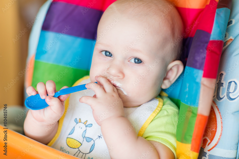 Adorable baby eating in high chair Adorable baby eating in high chair