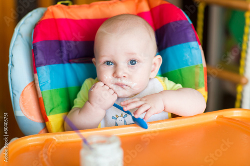 Adorable baby eating in high chair