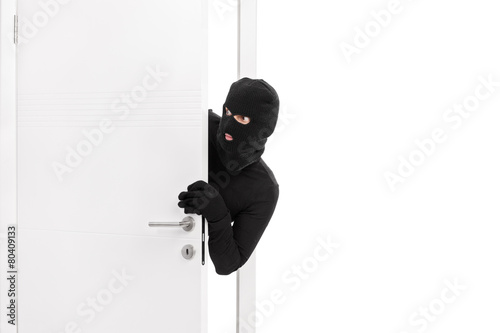 Fotografi Thief breaking into a room and carefully looking around