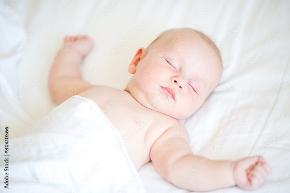 Peaceful newborn baby lying on a bed sleeping Peaceful newborn baby lying on a bed sleeping
