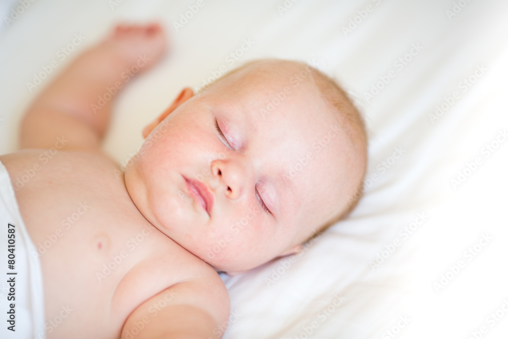 Peaceful newborn baby lying on a bed sleeping Peaceful newborn baby lying on a bed sleeping