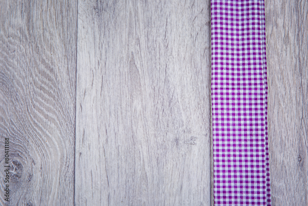 Purple checkered cloth son wooden background in rustic style