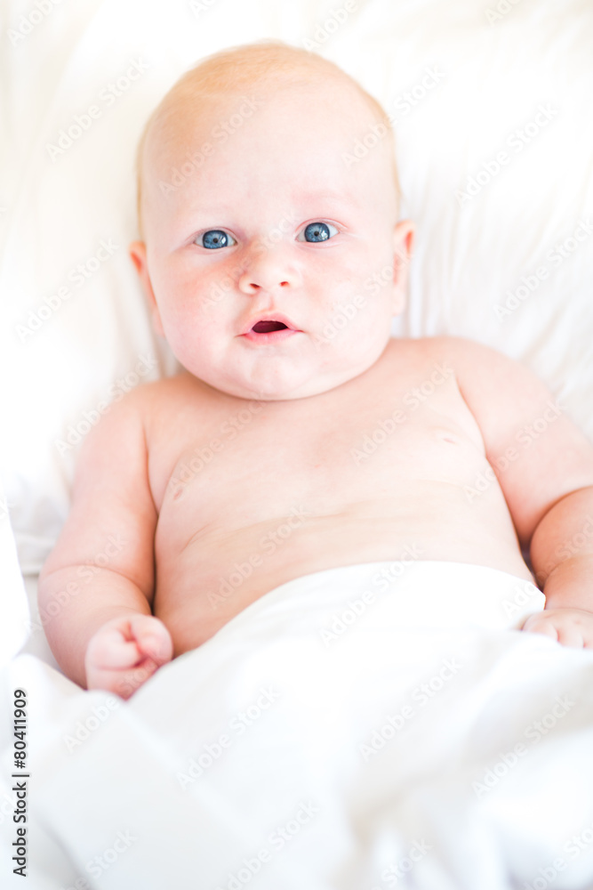 Peaceful newborn baby lying on a bed