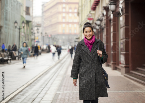Young Asian woman walking on spring city in Russia