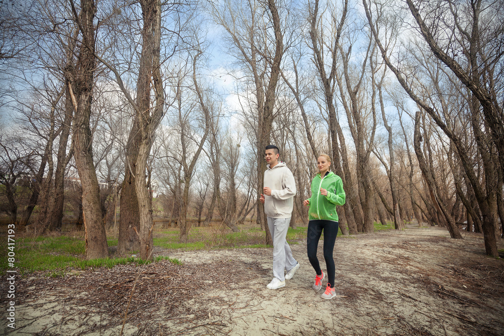 Two young people jogging in nature