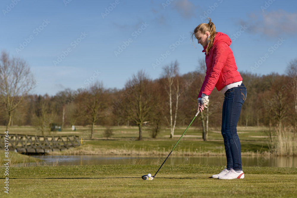 Obraz premium Frau beim Abschlag auf einem Golfplatz
