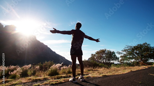 Triumphant African American athlete enjoying fitness in nature