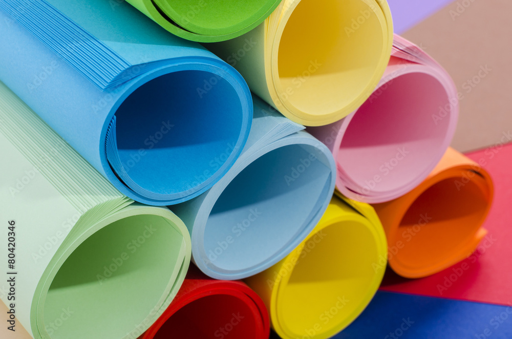 Roles of color paper piled.Stack of paper on color background. Roles of color paper piled.Stack of paper on color background.