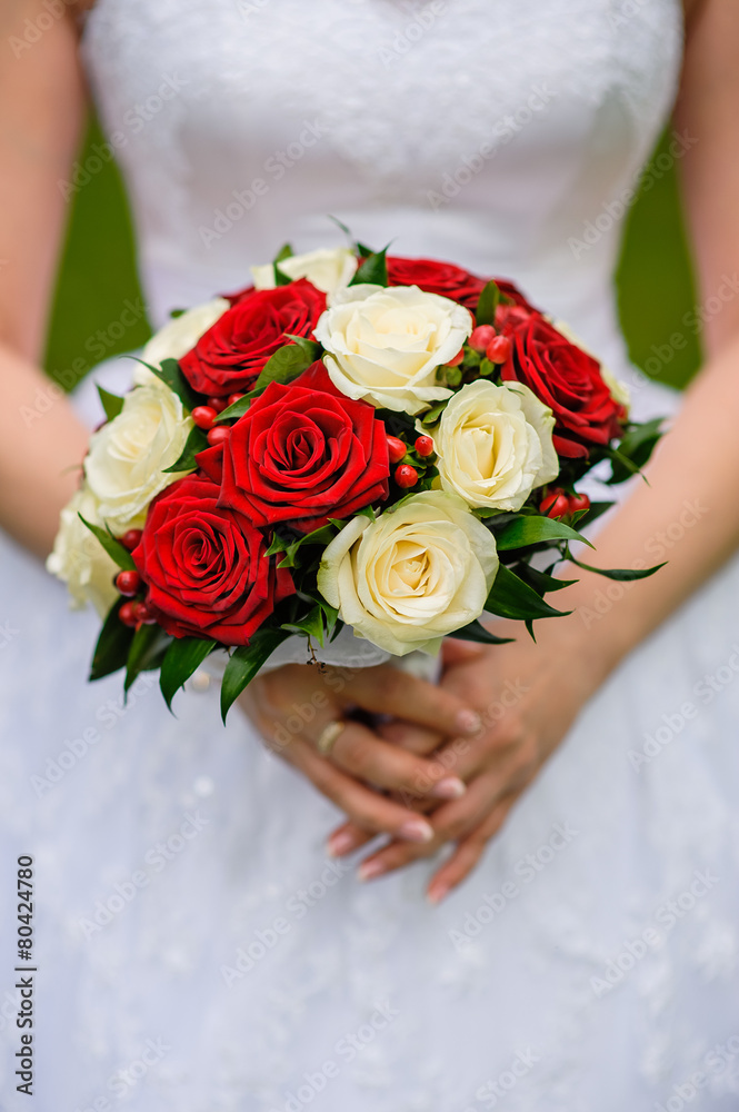 Wedding bouquet of roses in hands of the bride