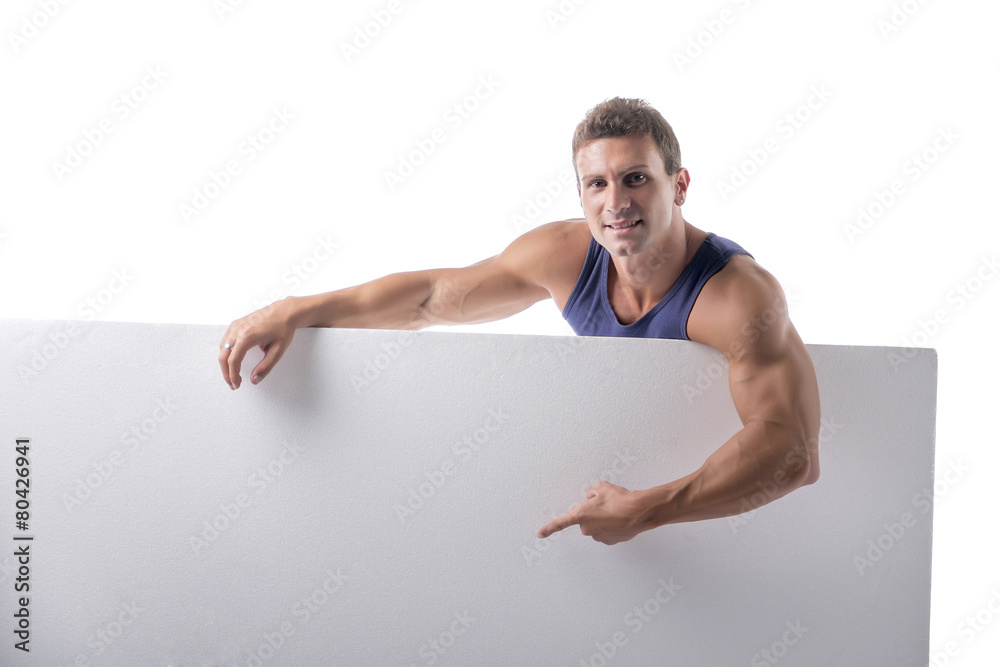 Strong muscular young man behind a blank horizontal white banner Strong muscular young man behind a blank horizontal white banner