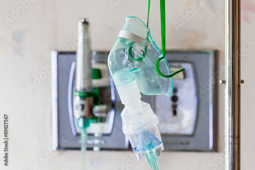 Close-up image of a medical oxygen mask and valve setting blurry