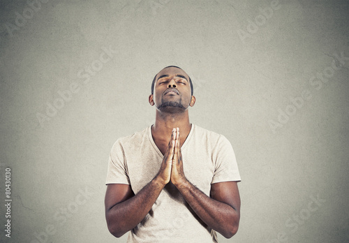 man praying hands clasped hoping for best gray background 