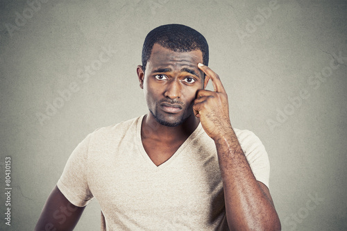 Preoccupied man scratching his head looking for solution