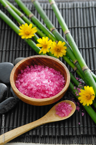 Spa setting with pink salt in bowl  black stone  bamboo grove on mat