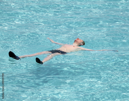 Maldives.Teenager has a rest on turquoise transparent water