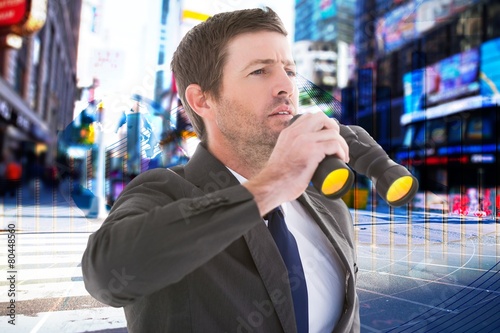 Focused handsome businessman holding binoculars