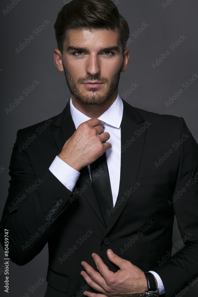 Handsome businessman adjusting his tie Handsome businessman adjusting his tie