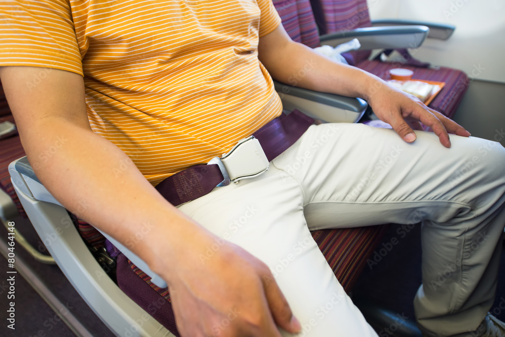 Close-up of man sitting wiht security belt on board