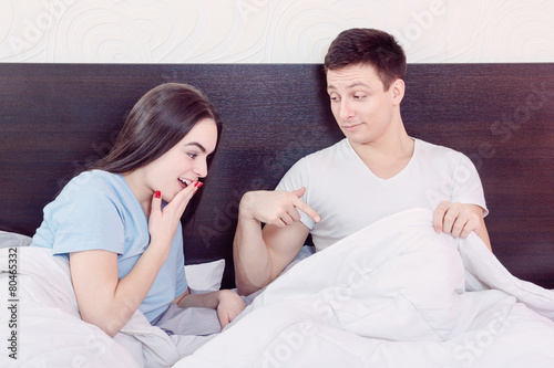 satisfied man sure in himself showing under cover in bedroom
