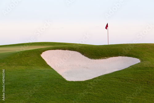 Heart shaped sand bunker in front of golf green