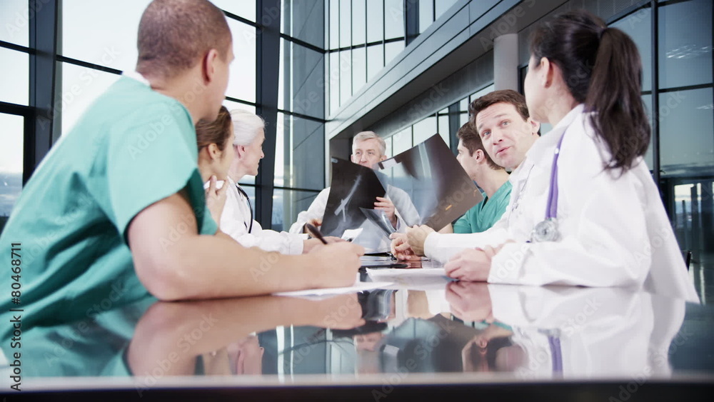 Multi ethnic medical team in a meeting discuss a patient's x-ray results Multi ethnic medical team in a meeting discuss a patient's x-ray results