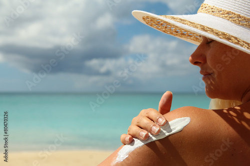 girl aplying  sun protection cream photo