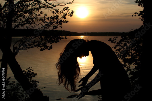 kobieta w jeziorze o zachodzie słońca