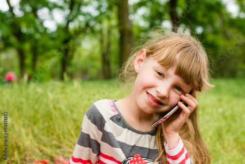 child with telephone on grass