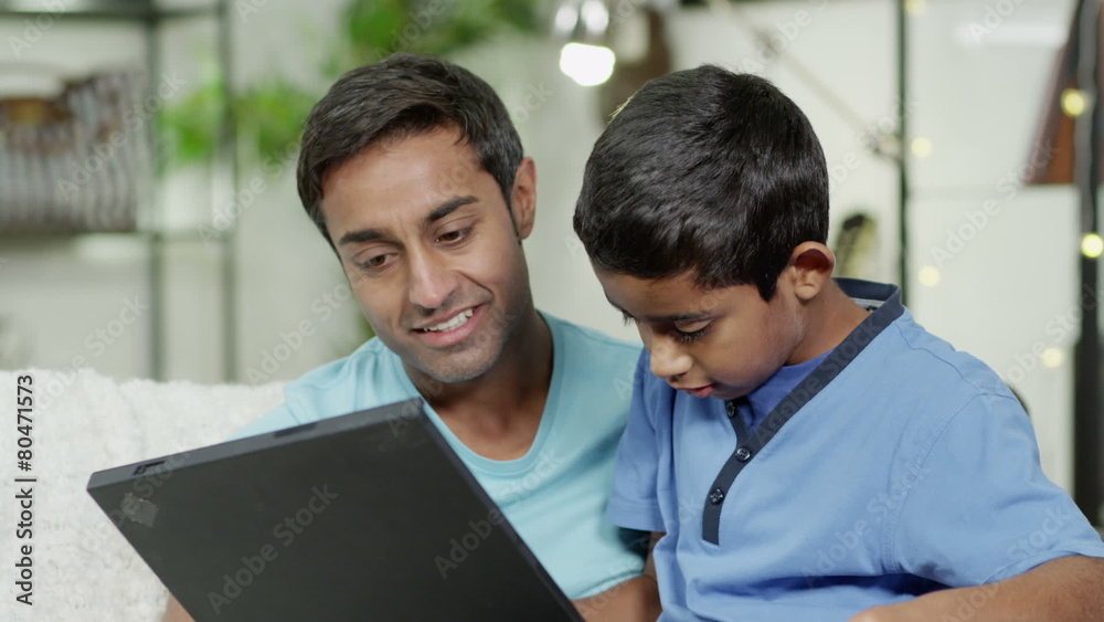 Father and son browsing the internet on a laptop computer