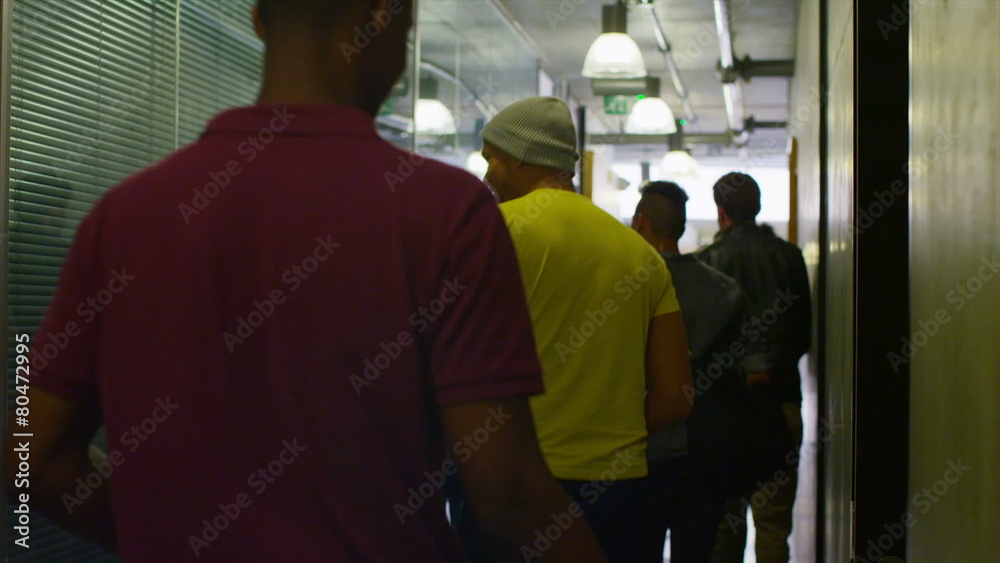 Young student group walking through the hallway in modern college building Young student group walking through the hallway in modern college building