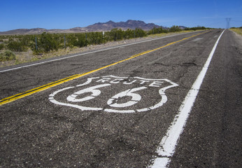 Acrylglasbilder Route 66 long road with a Route 66 sign painted on it  © tanaonte