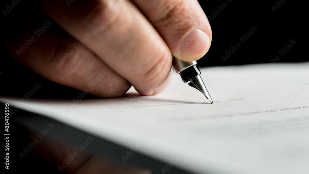 Macro shot of a hand of a businessman signing or writing a docum Macro shot of a hand of a businessman signing or writing a docum
