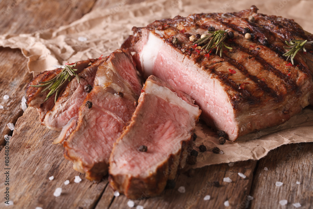 sliced beef steak medium on an old table. Horizontal close-up sliced beef steak medium on an old table. Horizontal close-up