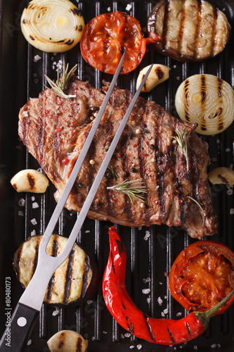 beef steak and vegetables on the grill. vertical background