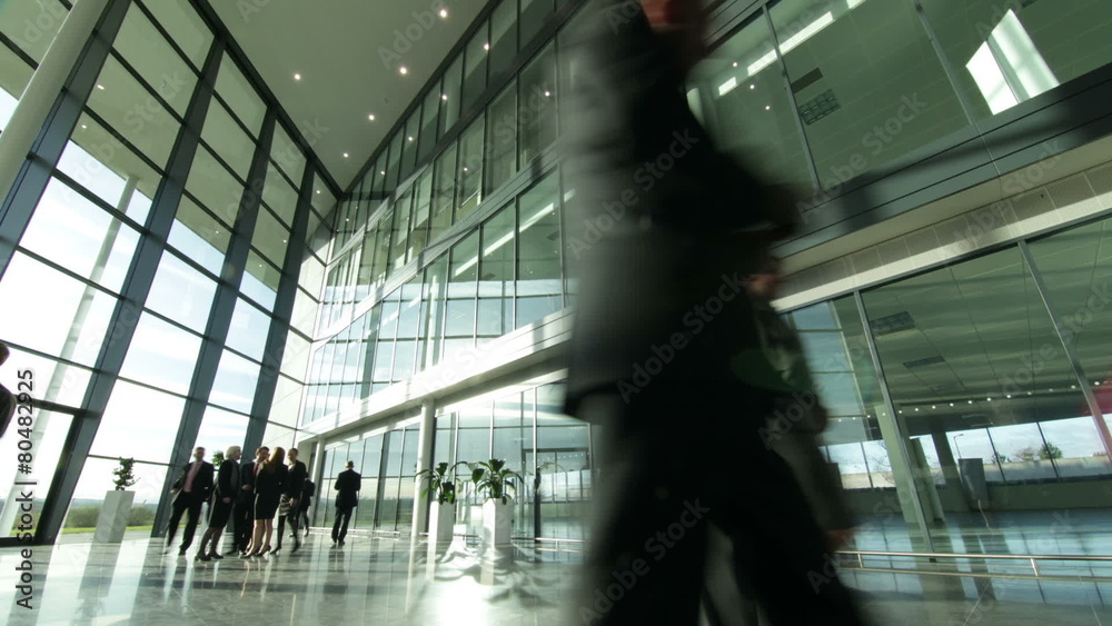Time lapse of large business group in a light and modern office building