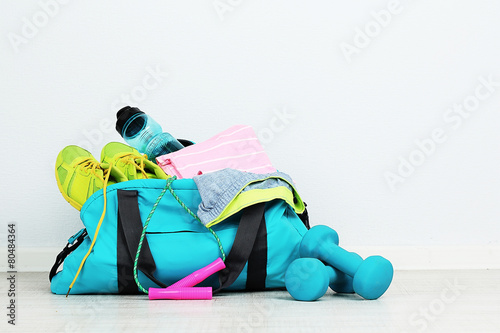 Sports bag with sports equipment in room photo