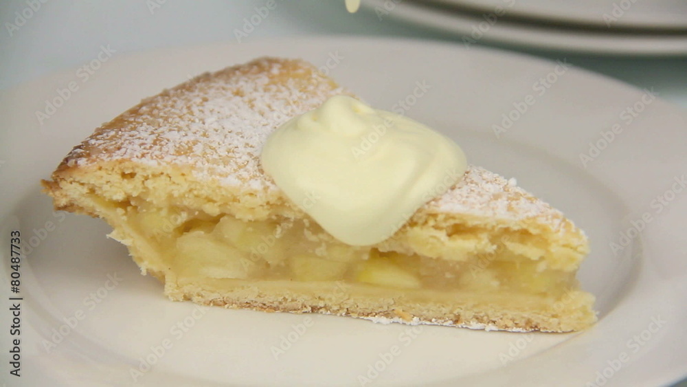 Berry compote is poured over a slice of apple pie with cream.