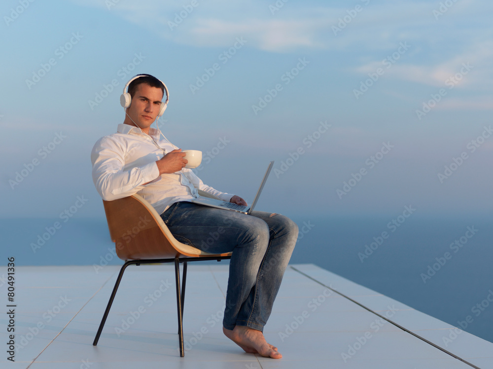 relaxed young man at home on balcony
