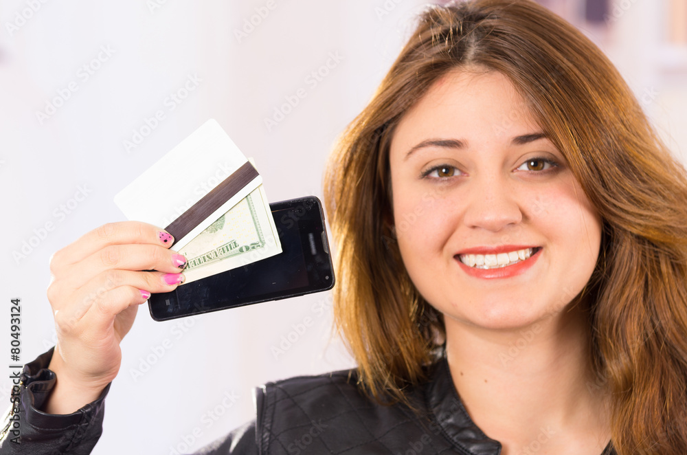 modern beautiful young woman holding cell phone, money and