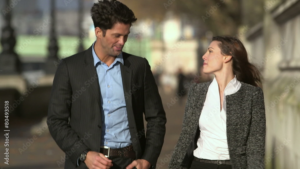 Young professional couple walking together through London