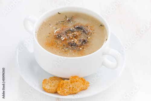 mushroom cream soup with croutons on white wooden table