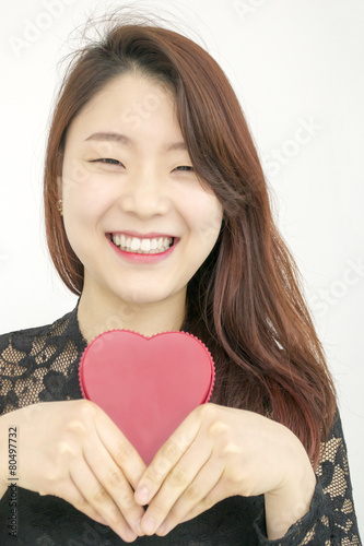 Smiling asian woman with red heart