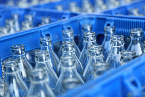 Quadro su tela Empty bottle in blue plastic crate