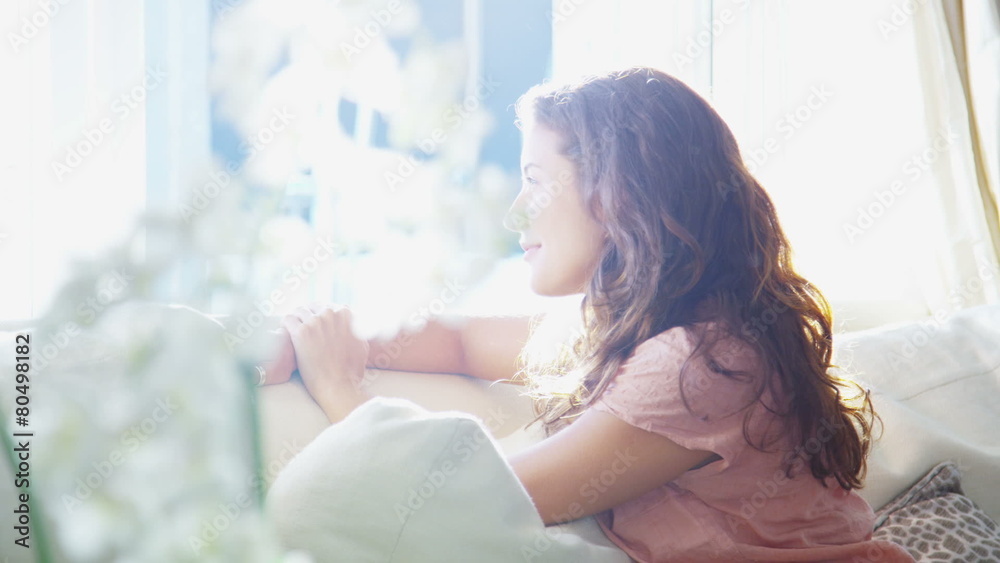 Attractive young woman alone with her thoughts sitting by the window Attractive young woman alone with her thoughts sitting by the window