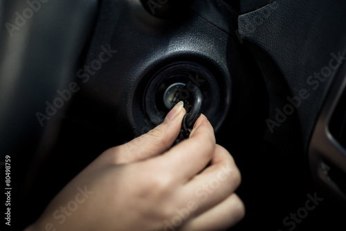 Closeup shot of woman inserting car key into the lock of ignitio