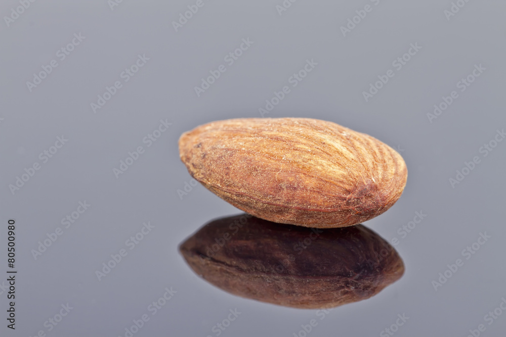 Obraz premium roasted almonds are on the reflecting surface