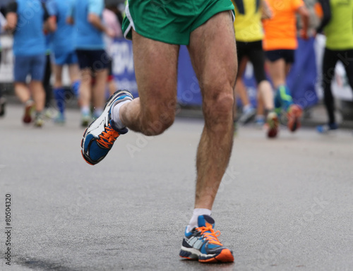 strong muscular legs of the athlete during the road race
